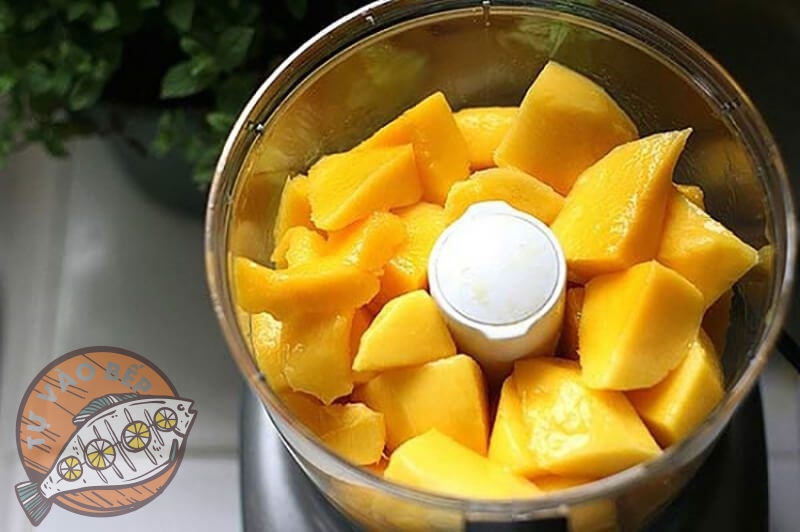 Xoài sau khi gọt vỏ thái miếng cho vào máy xay sinh tố xay nhuyễn